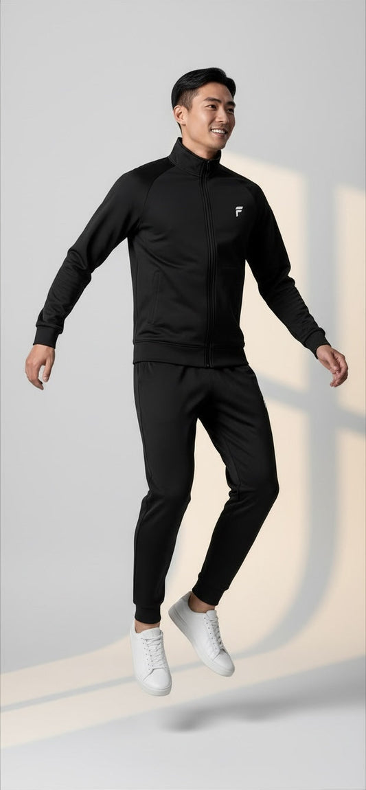 FITTING men's black full-zip athletic tracksuit with a high collar and tailored joggers worn by a smiling model.