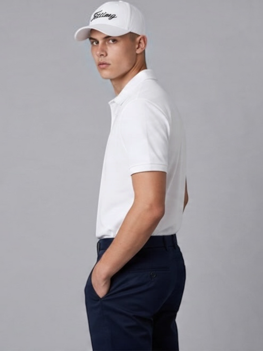 Model wearing a white FITTING baseball cap with black embroidered logo, paired with a white polo and navy chinos.