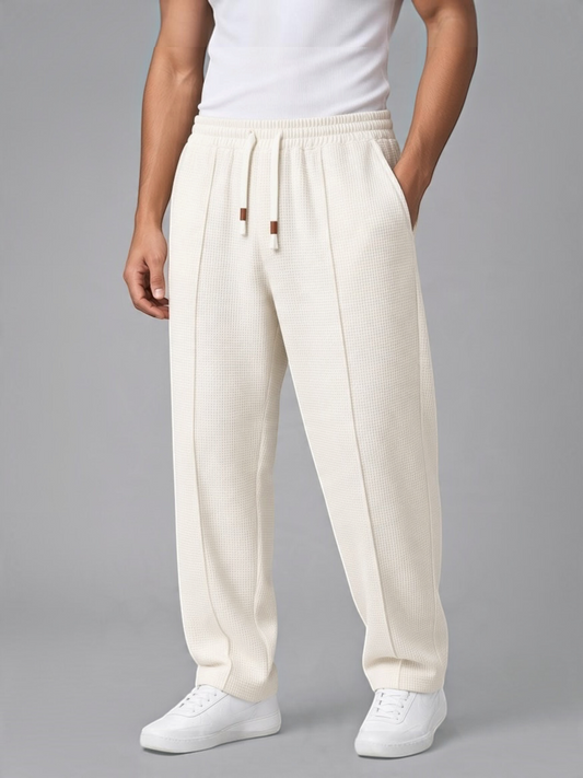 FITTING men's off-white waffle-knit lounge trousers with a drawstring waist, front seam detail, and side pockets.