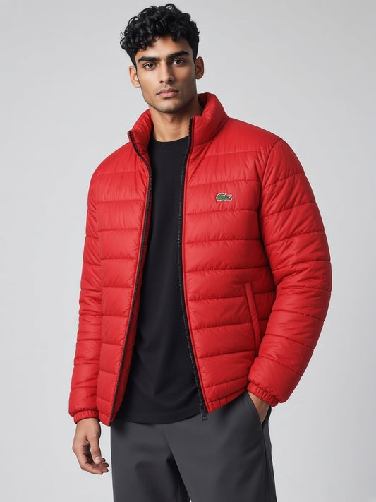 FITTING red quilted puffer jacket with a high-neck collar worn by a man against a grey background
